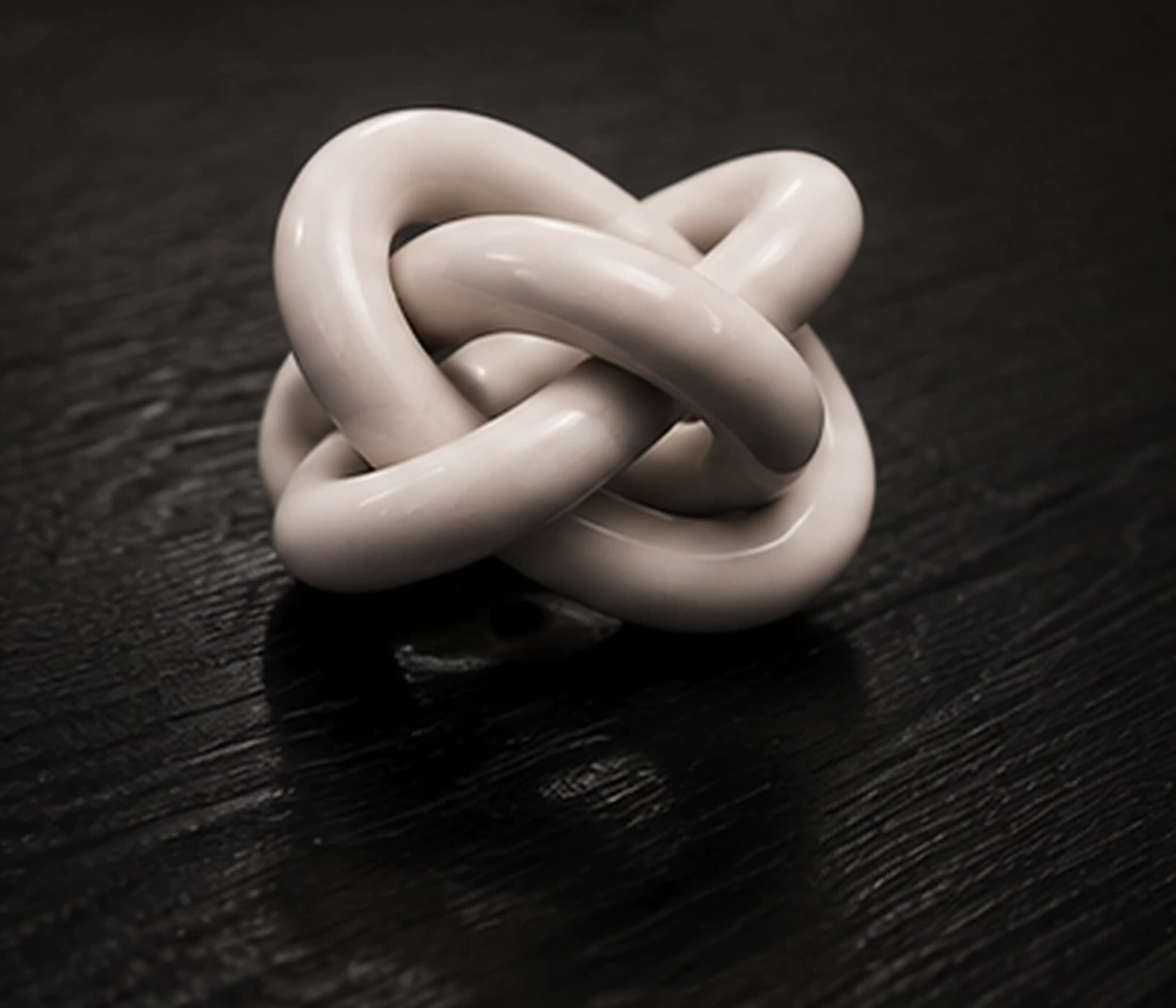 The hand-tied ceramic knot resting on the table's top