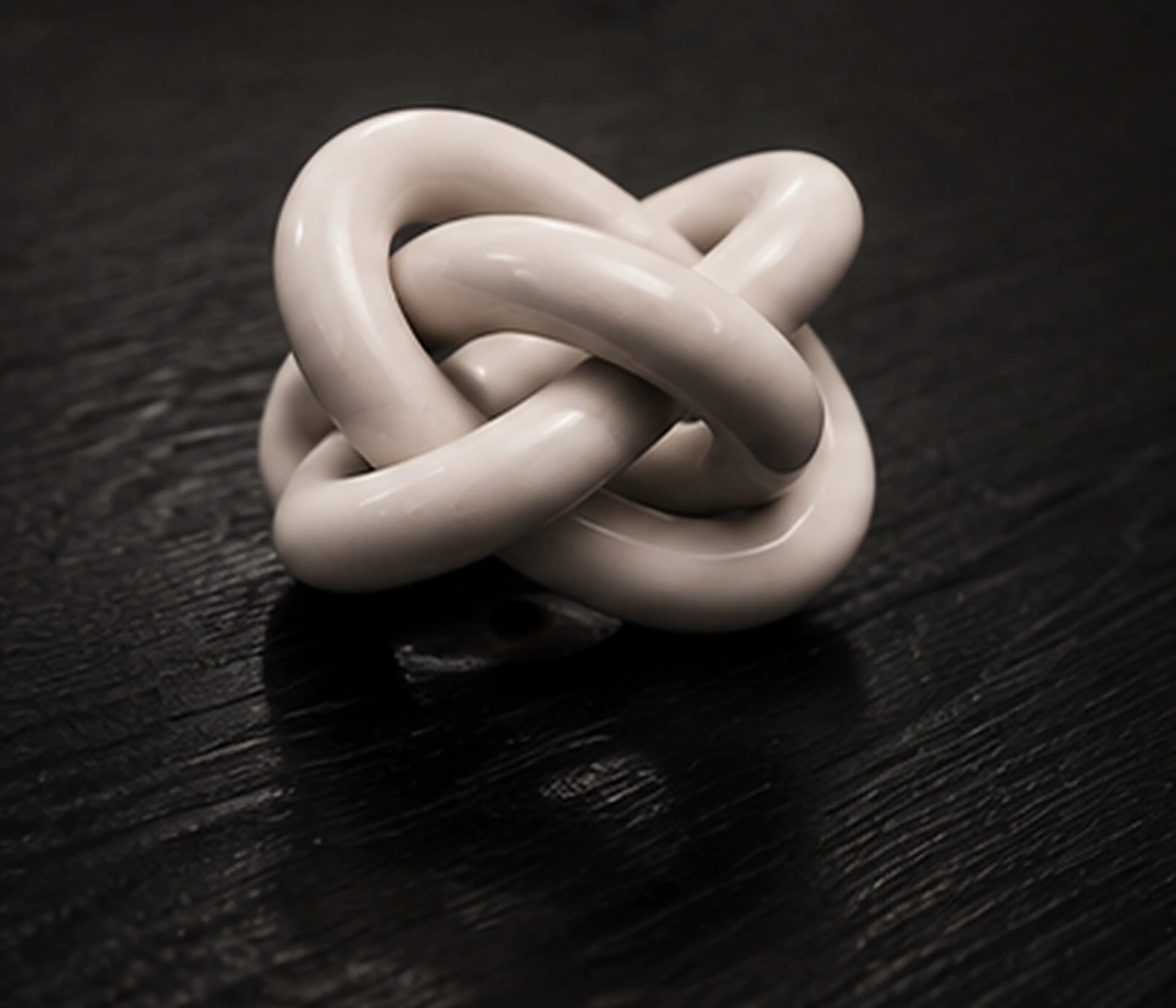 The hand-tied ceramic knot resting on the table's top