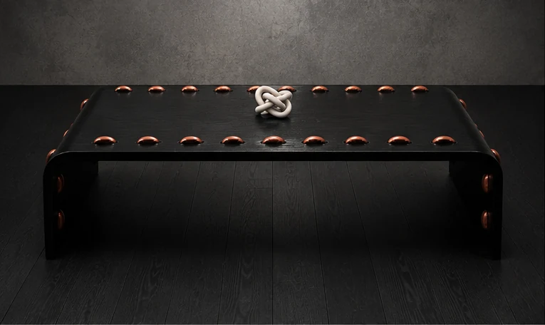 The Leather Stud Coffee Table, its black leather softened by years of use